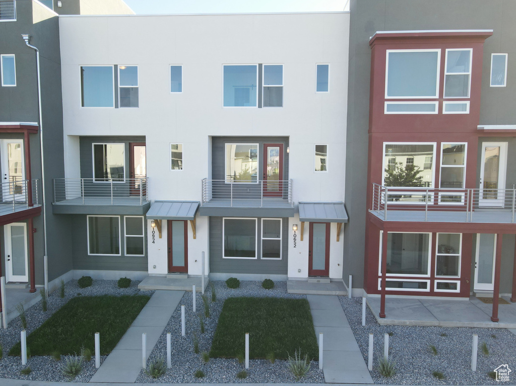 View of property with stucco siding, a standing seam roof, and metal roof