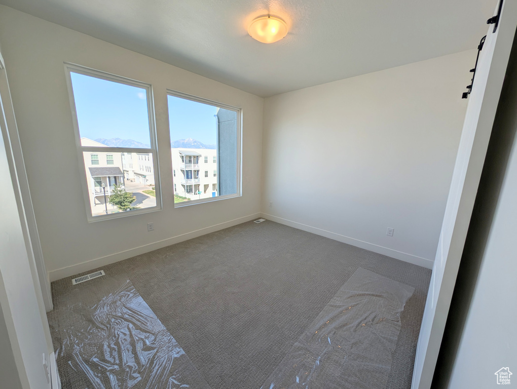 Empty room with carpet flooring and baseboards