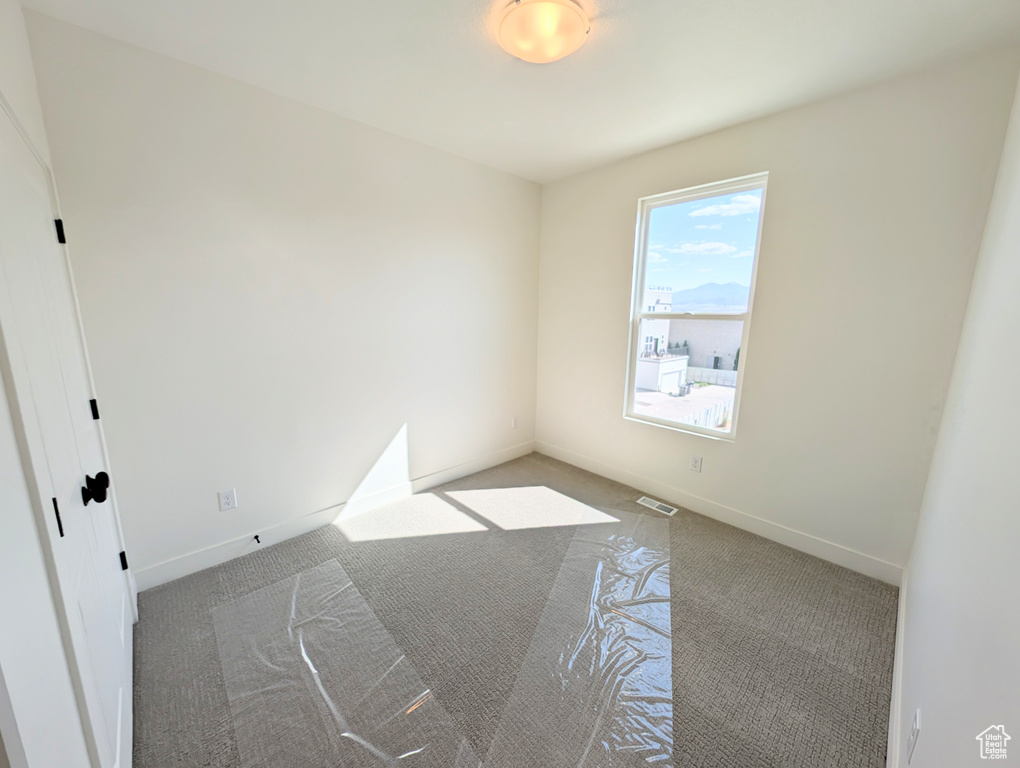 Unfurnished room featuring carpet and baseboards