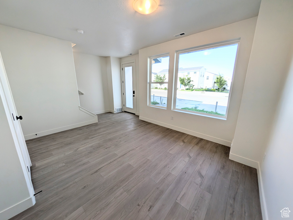 Spare room featuring wood finished floors, baseboards, and a smoke detector