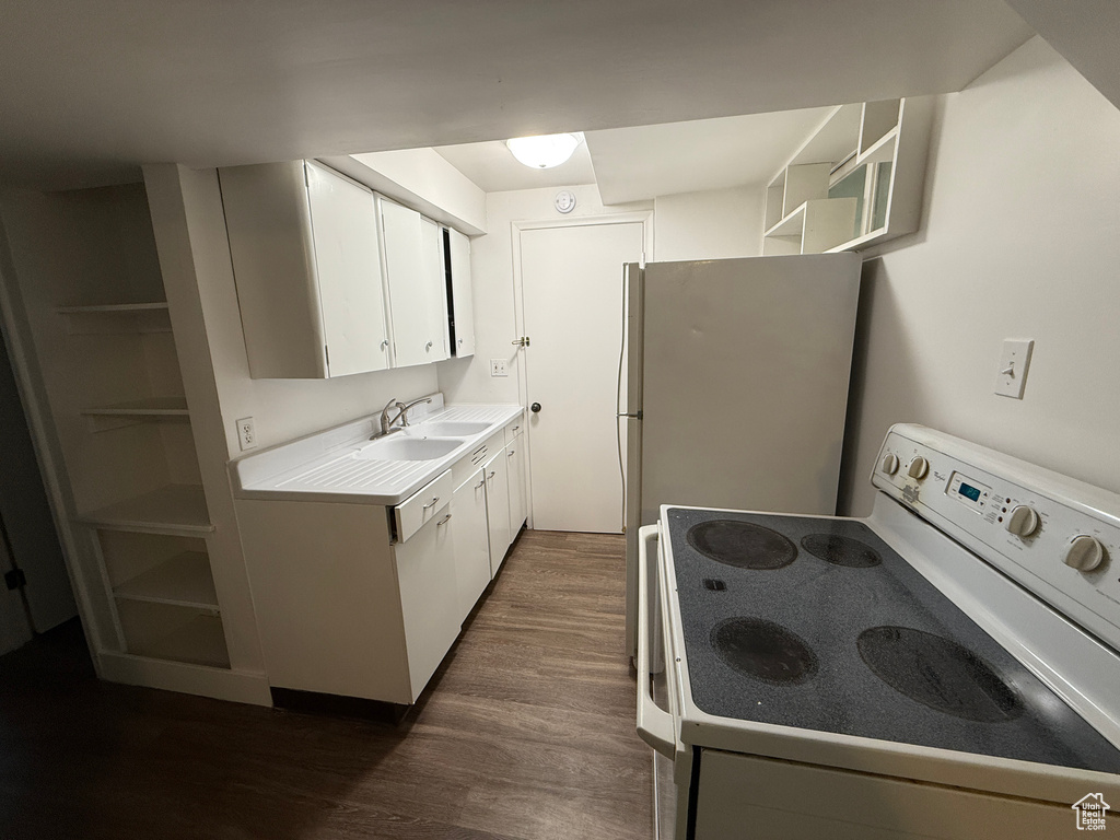 Kitchen with white appliances, a sink, open shelves, dark wood-style flooring, and white cabinetry