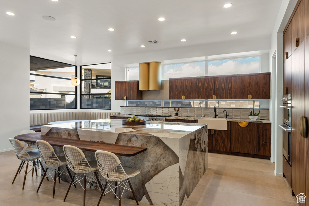 Kitchen featuring a sink, modern cabinets, backsplash, a kitchen island, and recessed lighting