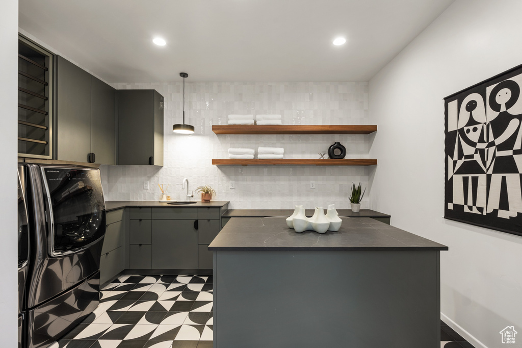 Kitchen with dark countertops, refrigerator, a sink, tile patterned floors, and recessed lighting