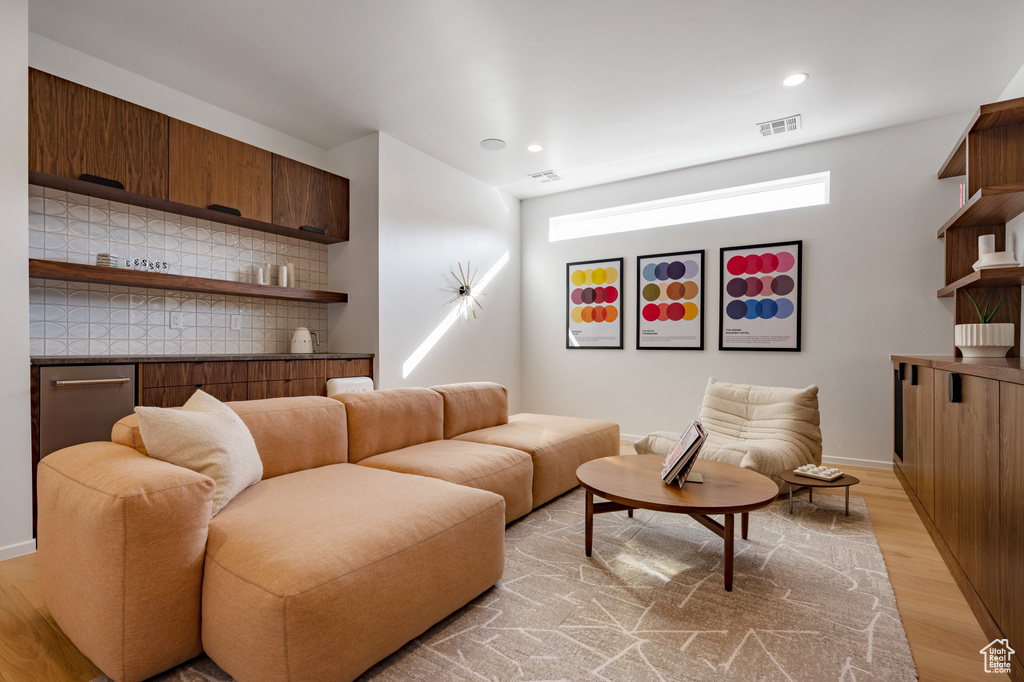 Living room with light wood finished floors, recessed lighting, and baseboards