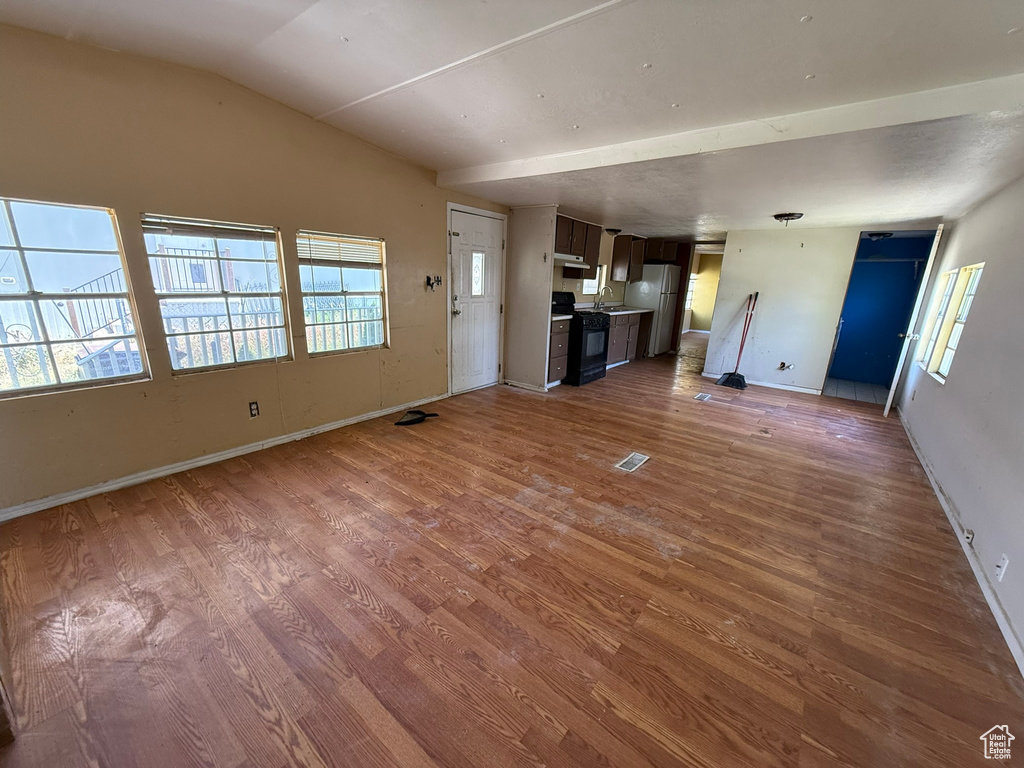 Unfurnished living room featuring wood finished floors and baseboards