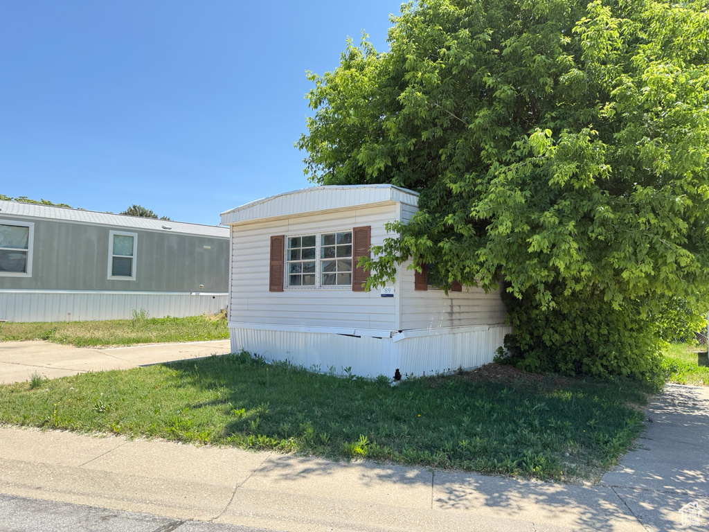 View of side of property featuring a lawn