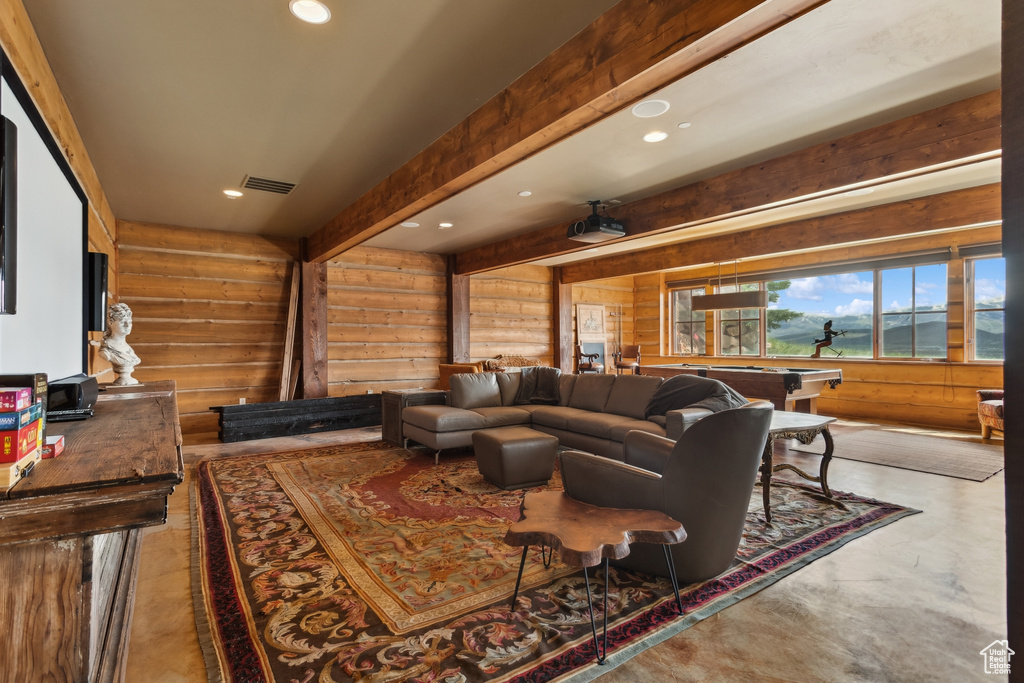 Living room with log walls, concrete floors, recessed lighting, and billiards table