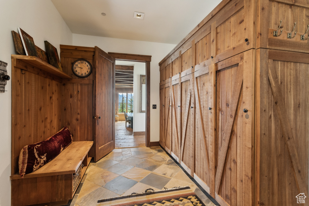 Mudroom with stone tile flooring and baseboards
