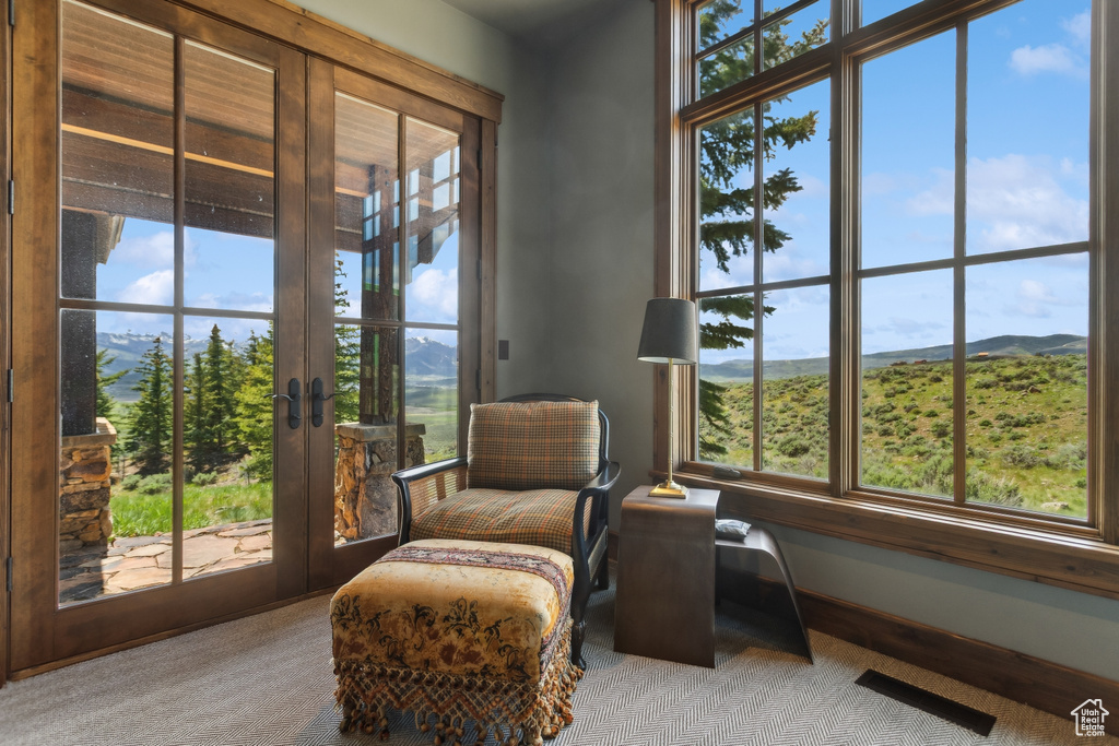 Living area with healthy amount of natural light, a mountain view, and french doors
