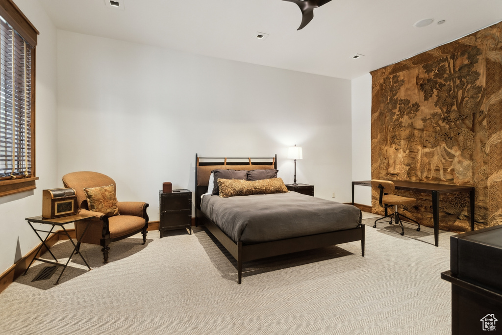 Carpeted bedroom featuring a ceiling fan