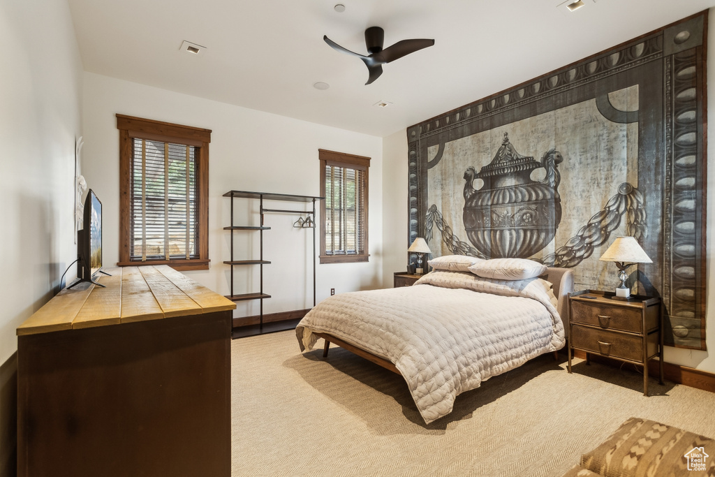 Bedroom with carpet floors, multiple windows, ceiling fan, and baseboards