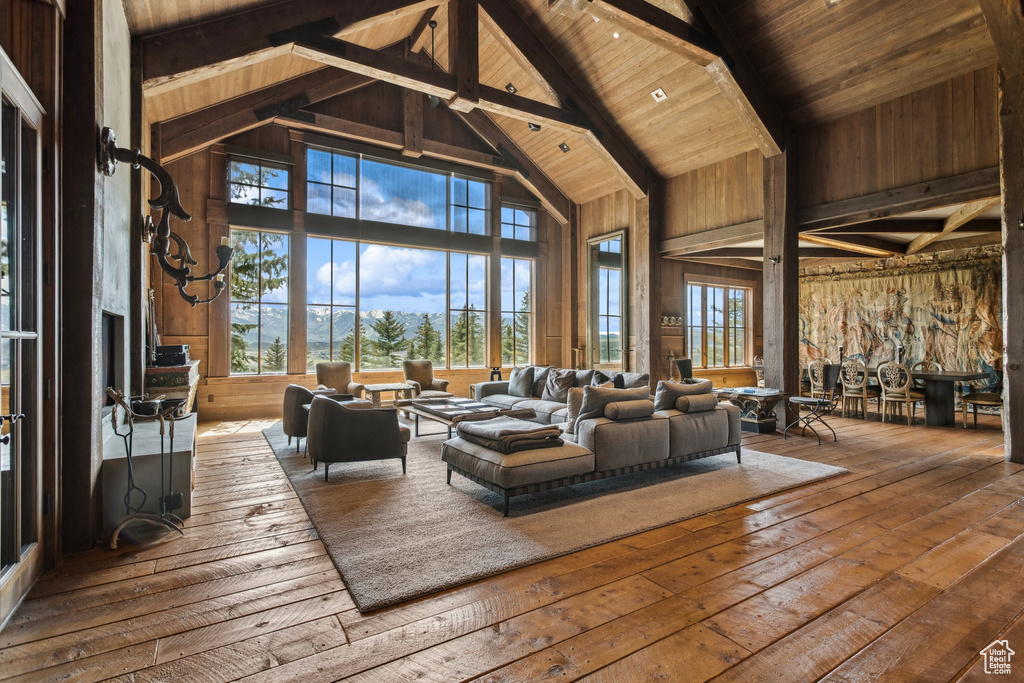 Living area with high vaulted ceiling, wooden ceiling with exposed beams, and hardwood / wood-style floors