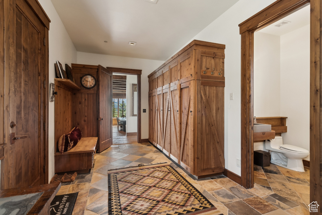 Mudroom with stone tile flooring and baseboards