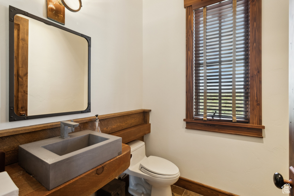 Bathroom with toilet, baseboards, and a sink
