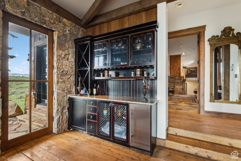 Indoor dry bar with hardwood / wood-style flooring