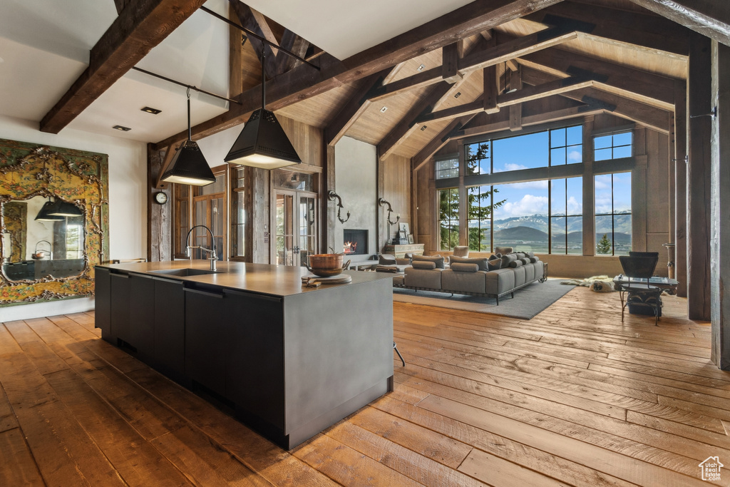 Living area with hardwood / wood-style floors, beamed ceiling, and high vaulted ceiling
