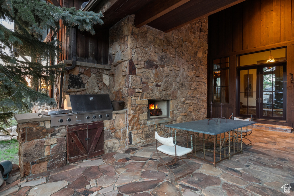 View of patio / terrace with a lit fireplace and outdoor dining space