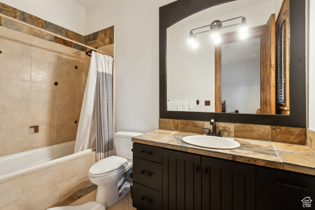 Full bathroom featuring vanity, tiled shower / bath, and toilet