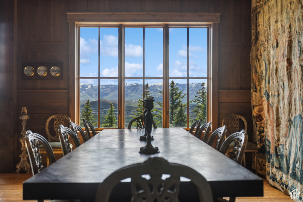 Dining area with wooden walls, a mountain view, and wood finished floors