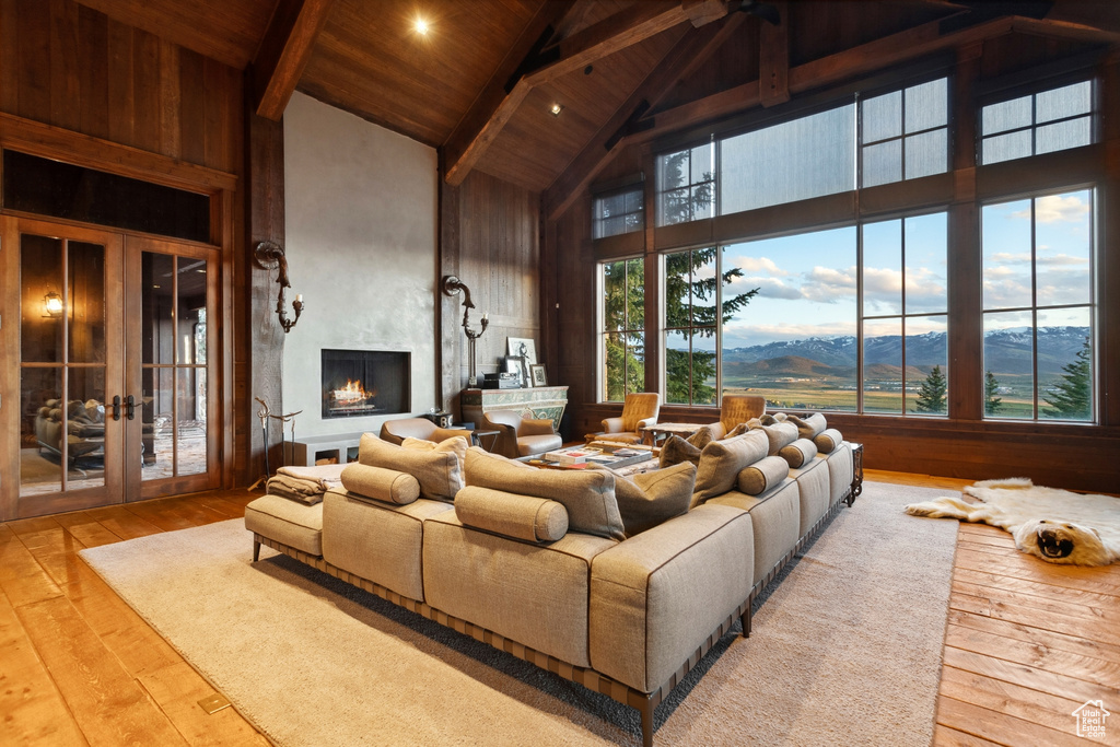 Living area featuring high vaulted ceiling, wood ceiling with exposed beams, hardwood / wood-style flooring, french doors, and a mountain view