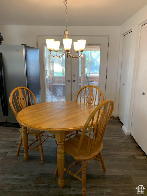 Dining space featuring a chandelier, dark wood-style floors, and baseboards