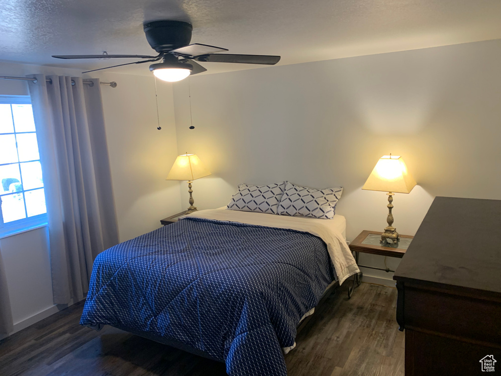 Bedroom featuring wood finished floors, ceiling fan, and a textured ceiling