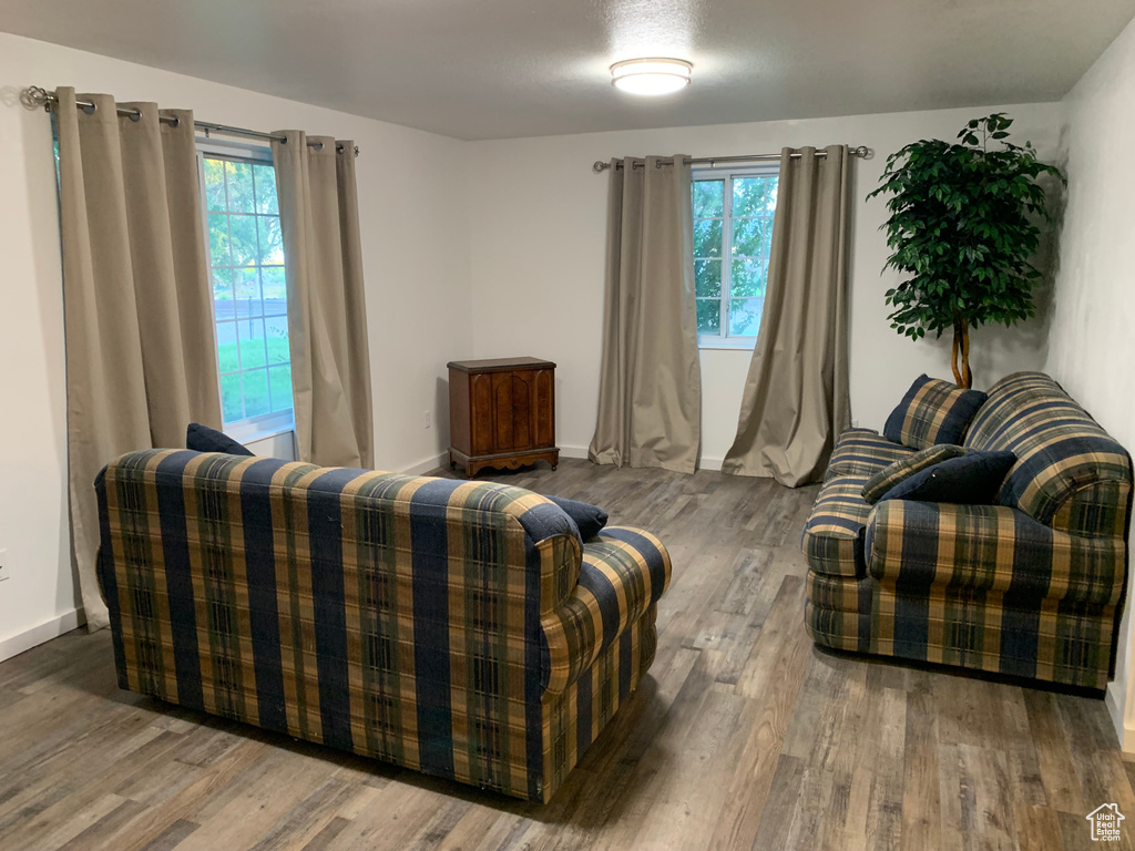Living area with wood finished floors, healthy amount of natural light, and baseboards