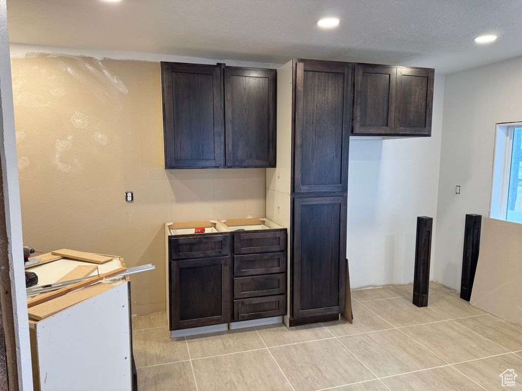 Kitchen with recessed lighting, light tile patterned flooring, light countertops, and dark brown cabinetry