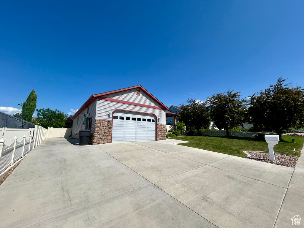 View of property exterior with stone siding and driveway