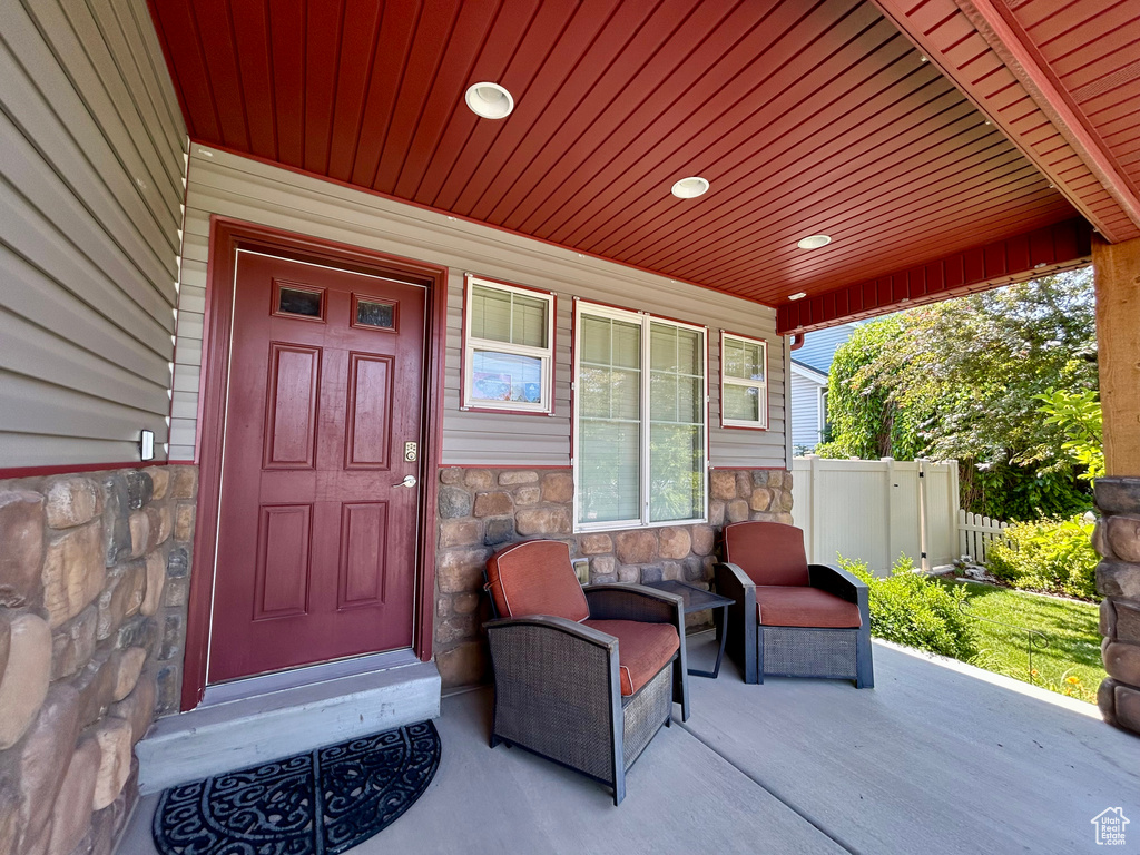 Entrance to property featuring stone siding and covered porch