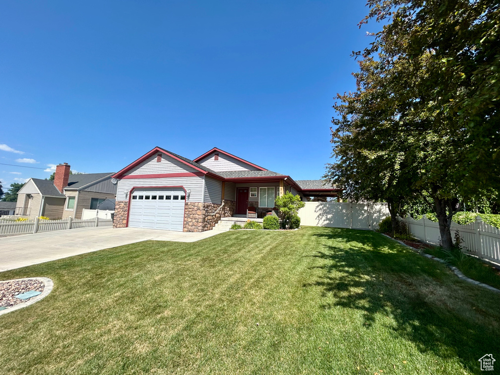 Single story home with stone siding, a garage, and driveway