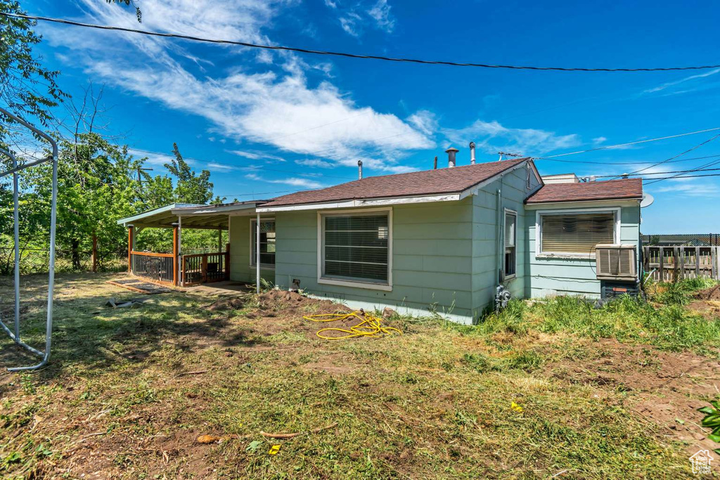 Rear view of house with a yard and cooling unit