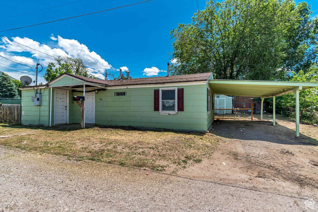 View of front of property with driveway and a carport