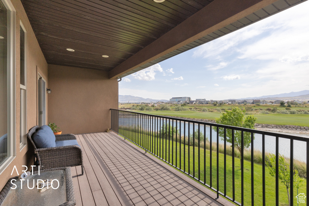 Balcony featuring a water and mountain view
