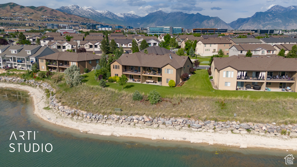 Aerial view of property and surrounding area featuring a water and mountain view and nearby suburban area