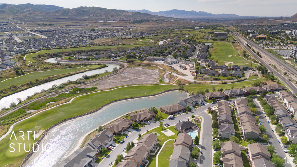 View of property location featuring nearby suburban area, a local golf course, and a water and mountain view