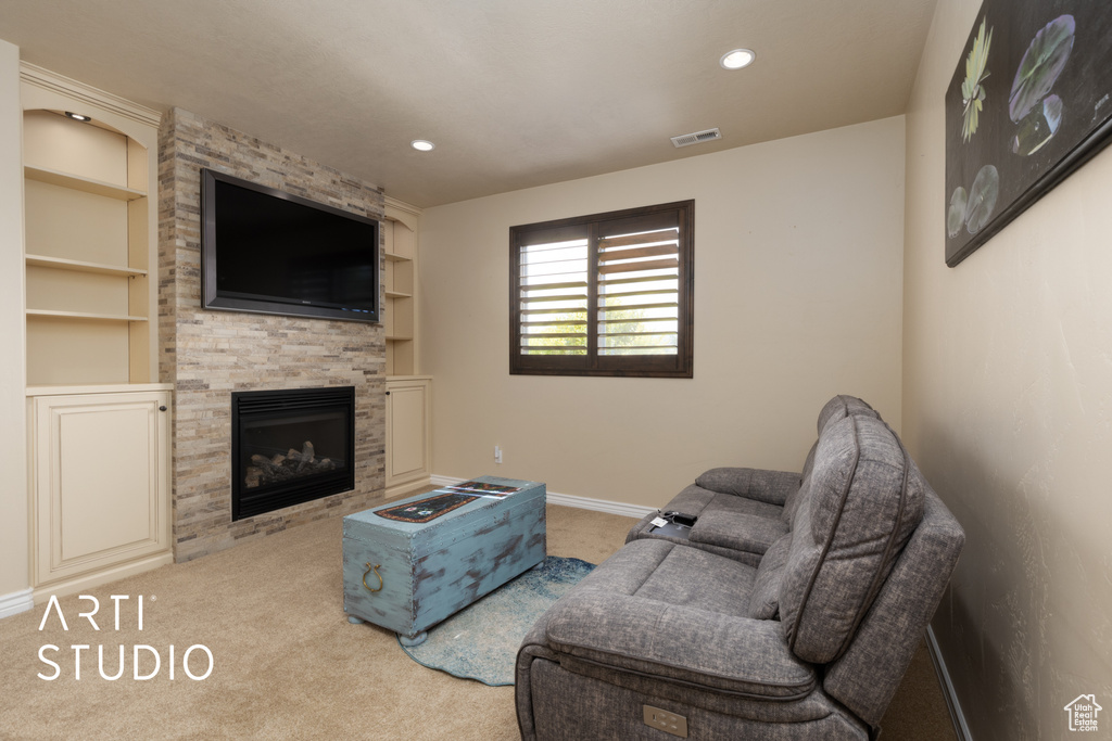 Living area with carpet floors, built in shelves, a fireplace, baseboards, and recessed lighting