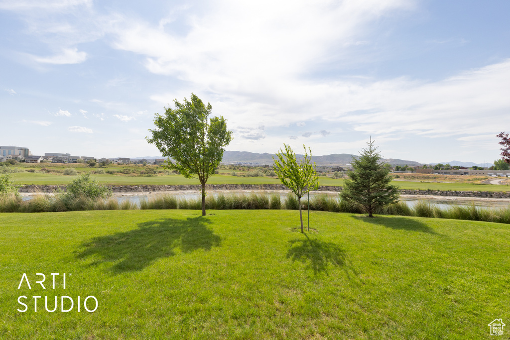View of grassy yard featuring a water and mountain view