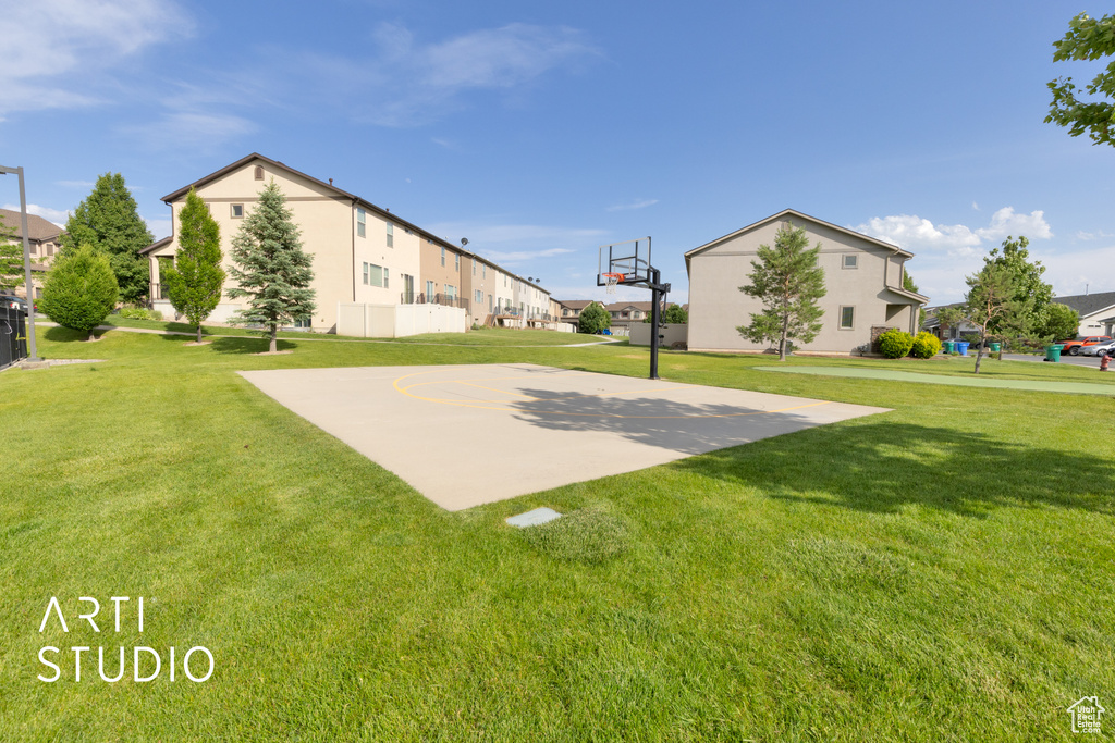 View of basketball court featuring community basketball court, a lawn, and a residential view