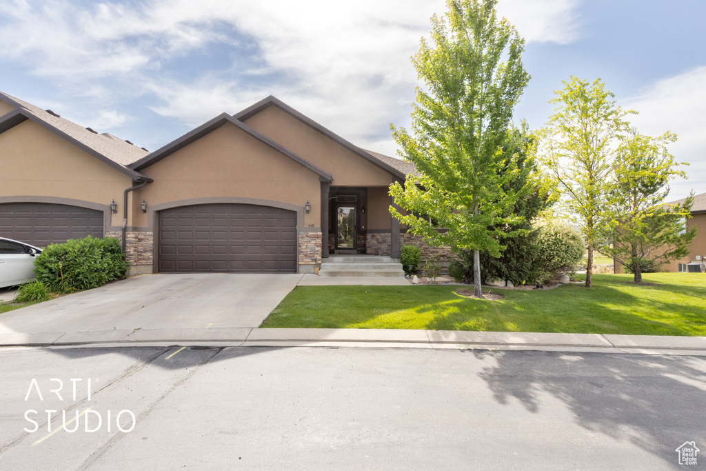 View of front of property featuring stucco siding, stone siding, an attached garage, and concrete driveway