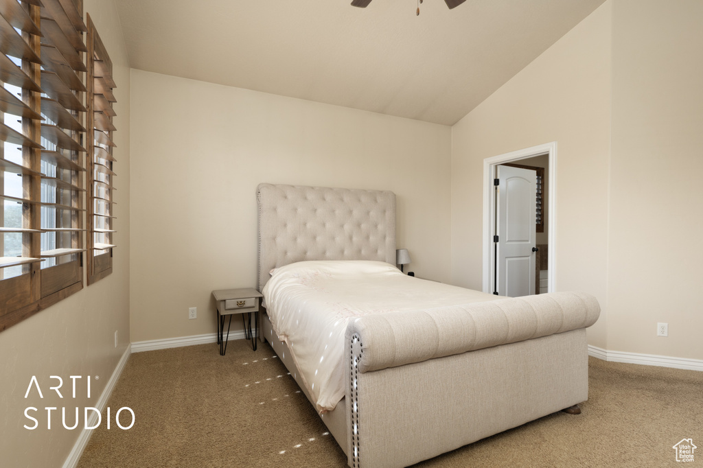 Carpeted bedroom featuring baseboards, vaulted ceiling, and a ceiling fan
