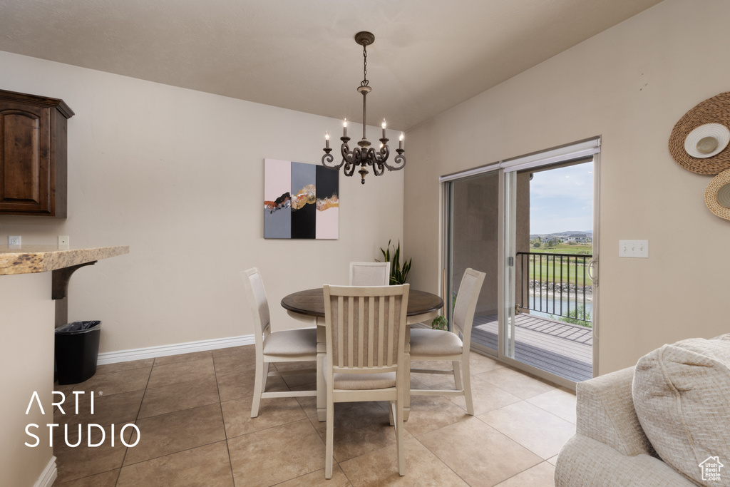 Dining room featuring a chandelier, light tile patterned floors, and baseboards