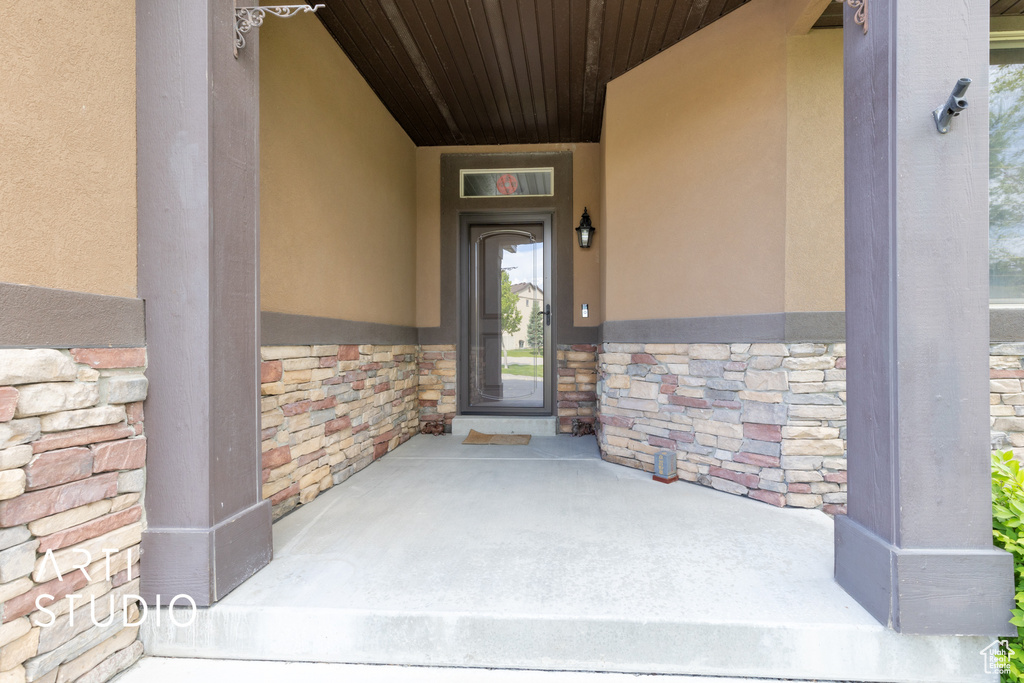 Doorway to property with stone siding and stucco siding