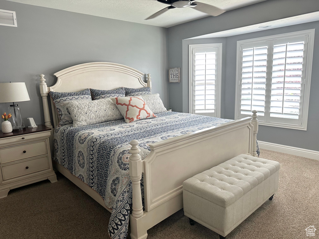Bedroom with carpet, baseboards, and a ceiling fan