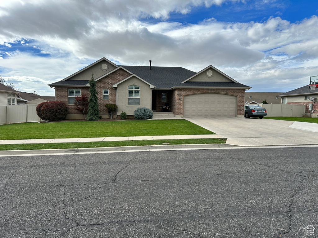 Ranch-style house with concrete driveway, brick siding, and an attached garage