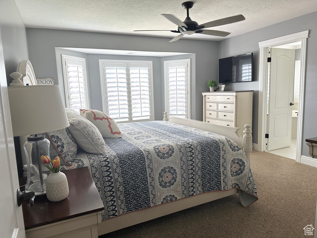 Bedroom with carpet floors, a textured ceiling, and a ceiling fan