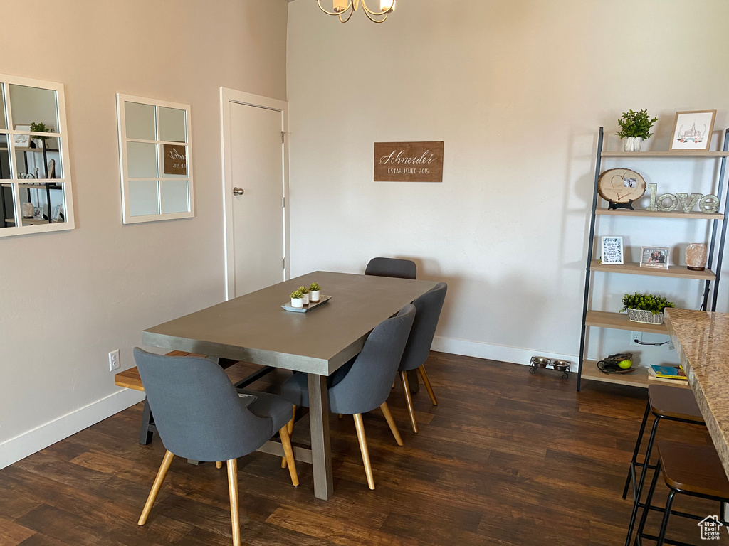 Dining area with dark wood finished floors, baseboards, and a chandelier