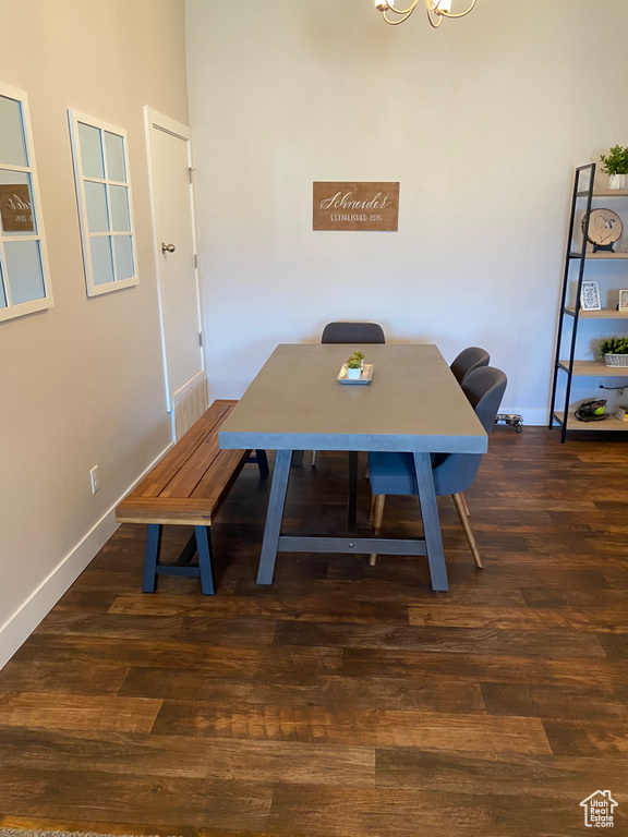 Dining area with an office area, dark wood-style flooring, a chandelier, and baseboards