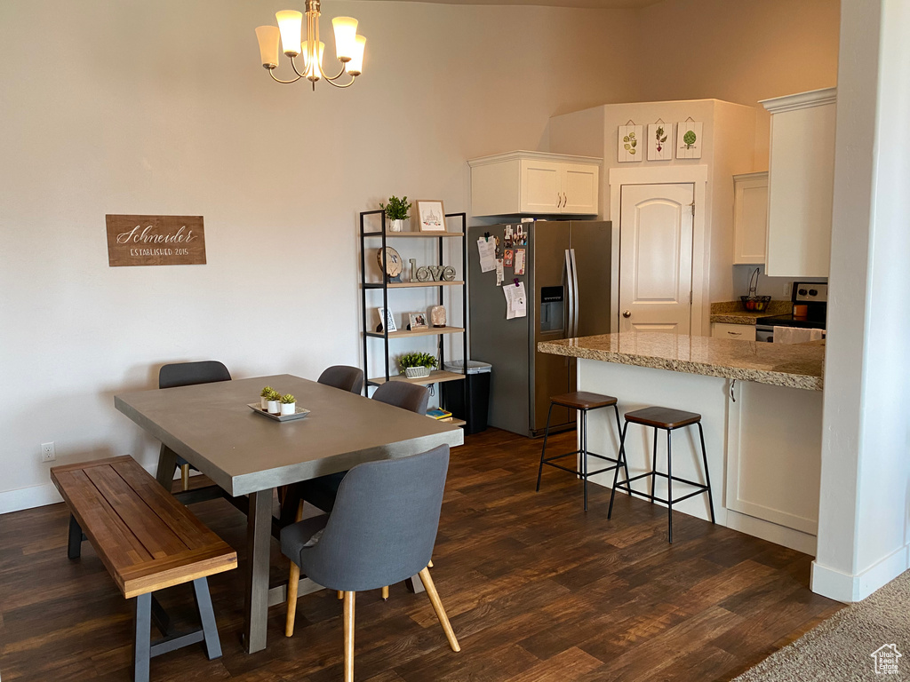 Dining space featuring a chandelier, dark wood-style flooring, and baseboards