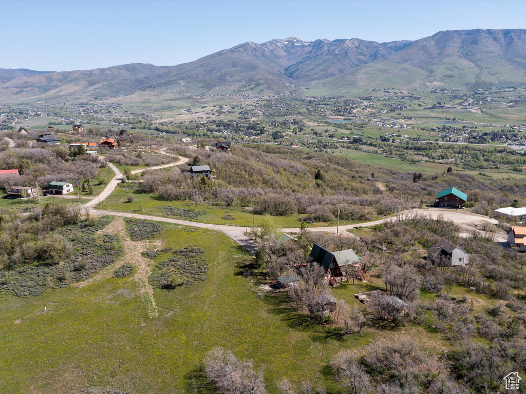 Aerial view of property and surrounding area with a mountain backdrop